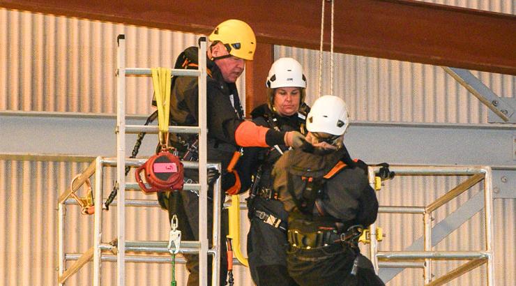 Offshore wind training participants practice securing themselves for safety.